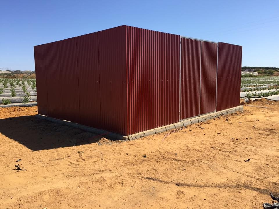 Nave agrícola exterior revestida en panel sándwich rojo