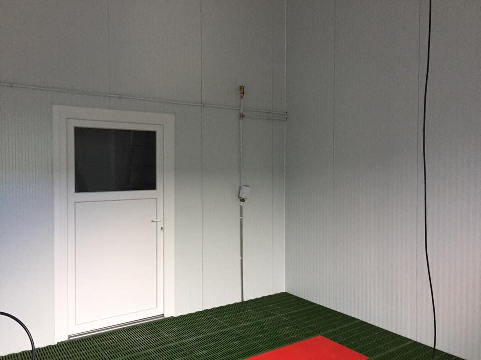 Dos puertas de garaje seccionales grises en fachada de local comercial